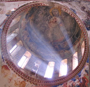 Inside of a ancient christianity cathedral dome in Georgia with frescoes and windows letting in light