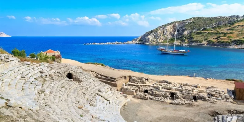 John Graham Tours Castles of Caria cruising tour. Image of ampitheater at Knidos with gulet in the blue bay.